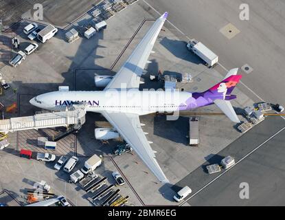 Das Flugzeug der Hawaiian Airlines Airbus A330 hat am Flughafen LAX, USA angedockt. Luftaufnahme eines Flugzeugs, das mit einer Düsenbrücke verbunden ist. A330-200 N370HA. Stockfoto