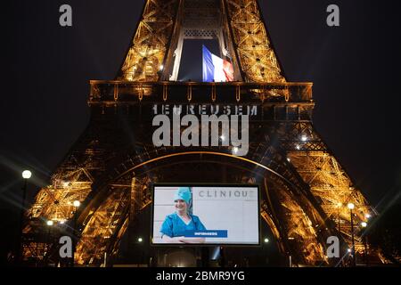 Paris, Frankreich. Mai 2020. Ein Porträt einer Krankenschwester, die während der COVID-19-Pandemie mobilisiert wurde, wird während einer Tribute auf einer riesigen Leinwand vor dem Eiffelturm in Paris, Frankreich, am 10. Mai 2020 gezeigt. Kredit: Jack Chan/Xinhua/Alamy Live News Stockfoto