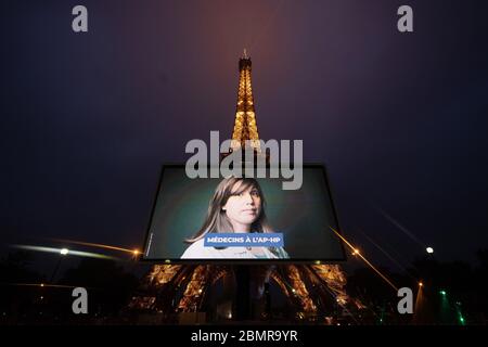 Paris, Frankreich. Mai 2020. Ein Porträt eines Arztes, der während der COVID-19-Pandemie mobilisiert wurde, wird während einer Tribute auf einer riesigen Leinwand vor dem Eiffelturm in Paris, Frankreich, am 10. Mai 2020 gezeigt. Kredit: Jack Chan/Xinhua/Alamy Live News Stockfoto