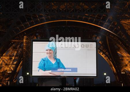 Paris, Frankreich. Mai 2020. Ein Porträt einer Krankenschwester, die während der COVID-19-Pandemie mobilisiert wurde, wird während einer Tribute auf einer riesigen Leinwand vor dem Eiffelturm in Paris, Frankreich, am 10. Mai 2020 gezeigt. Kredit: Jack Chan/Xinhua/Alamy Live News Stockfoto