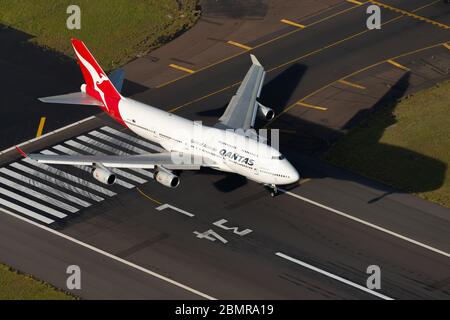 Qantas Airways Boeing 747 über der Startbahnschwelle des Sydney International Airport vor der Landung. Luftaufnahme der australischen Fluggesellschaft Jumbo 747-400 Landung. Stockfoto