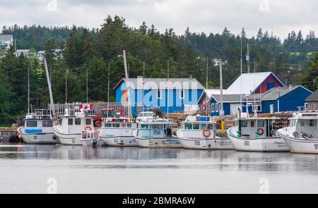 North Rustico Harbour – ein malerisches Fischerdorf auf Prince Edward Island, Kanada. Boote liegen am Dock. Fischerhütten säumen die Küste. Stockfoto