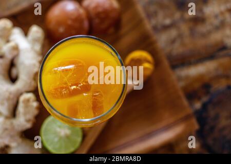 Ein Glas Jamu 'Kunir Asam', traditionelle indonesische Kräutermedizin. Serviert mit Eis. Bali, Indonesien. Draufsicht. Mit Platz. Stockfoto