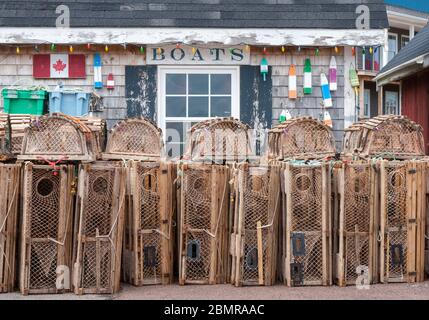 Gestapelte Hummerfallen vor einer malerischen Fischerhütte, an den Docks. North Rustico Harbour, Prince Edward Island, Kanada Stockfoto