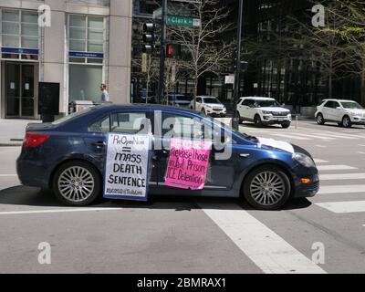 Chicago, Illinois, USA. Mai 2020. Ein Auto mit Schildern protestiert heute gegen den COVID-19 Shutdown Protest im Thompson Center. Stockfoto