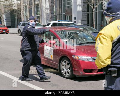 Chicago, Illinois, USA. Mai 2020. Ein Polizist leitet einen Protest gegen die heutige COVID-19-Abschaltung von dem Protest im Thompson Center weg. Stockfoto