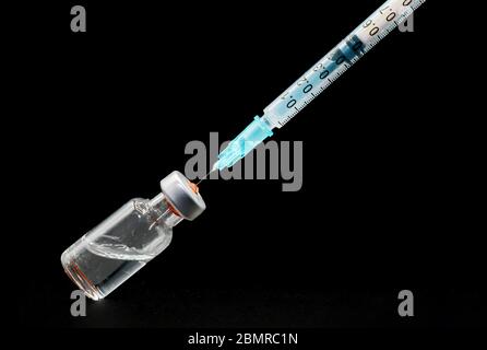 Nahaufnahme, Vorbereitung der Spritze und Fläschchen, für die Impfung, auf schwarzem, isoliertem Hintergrund . Stockfoto