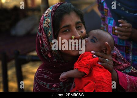 Lahore, Pakistan. Mai 2020. Die pakistanische Mutter spielt und drückt ihre Zuneigung zu ihrem Kind am Vorabend des Muttertages am Ufer des Flusses Ravi in Lahore aus. Der Muttertag wird jährlich am zweiten Sonntag im Mai weltweit gefeiert.Pakistan gemeinsam mit ihren Babys ist es eine Feier, die die Mutter der Person ehrt, sowie die Mutterschaft, die mütterlichen Bindungen und den Einfluss der Mütter in der Gesellschaft. Mother's Day stammte hauptsächlich von zwei Frauen, Julia ward Howe und Anna Jarvis. Quelle: Pacific Press Agency/Alamy Live News Stockfoto