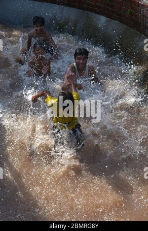 Lahore, Pakistan. Mai 2020. Pakistanische Jugendliche genießen Bad im Kanalwasser, um die Hitze zu schlagen und etwas Erleichterung von warmem Wetter in Ramazan-ul-Mubarak in Lahore. (Foto von Rana Sajid Hussain/Pacific Press) Quelle: Pacific Press Agency/Alamy Live News Stockfoto