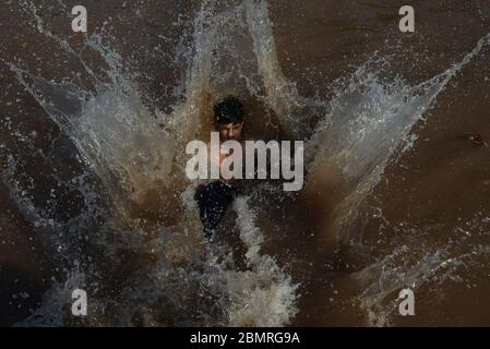 Lahore, Pakistan. Mai 2020. Pakistanische Jugendliche genießen Bad im Kanalwasser, um die Hitze zu schlagen und etwas Erleichterung von warmem Wetter in Ramazan-ul-Mubarak in Lahore. (Foto von Rana Sajid Hussain/Pacific Press) Quelle: Pacific Press Agency/Alamy Live News Stockfoto