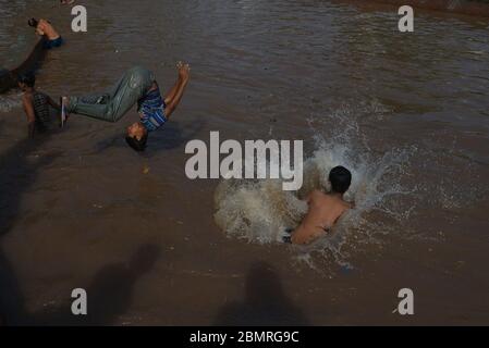Lahore, Pakistan. Mai 2020. Pakistanische Jugendliche genießen Bad im Kanalwasser, um die Hitze zu schlagen und etwas Erleichterung von warmem Wetter in Ramazan-ul-Mubarak in Lahore. (Foto von Rana Sajid Hussain/Pacific Press) Quelle: Pacific Press Agency/Alamy Live News Stockfoto