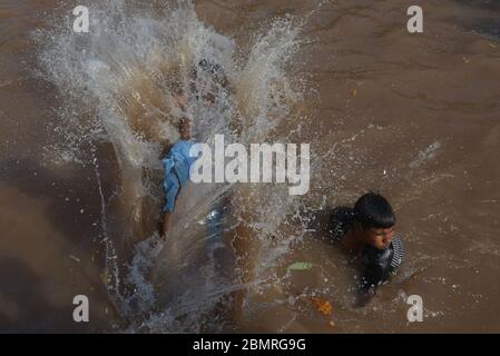 Lahore, Pakistan. Mai 2020. Pakistanische Jugendliche genießen Bad im Kanalwasser, um die Hitze zu schlagen und etwas Erleichterung von warmem Wetter in Ramazan-ul-Mubarak in Lahore. (Foto von Rana Sajid Hussain/Pacific Press) Quelle: Pacific Press Agency/Alamy Live News Stockfoto