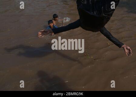 Lahore, Pakistan. Mai 2020. Pakistanische Jugendliche genießen Bad im Kanalwasser, um die Hitze zu schlagen und etwas Erleichterung von warmem Wetter in Ramazan-ul-Mubarak in Lahore. (Foto von Rana Sajid Hussain/Pacific Press) Quelle: Pacific Press Agency/Alamy Live News Stockfoto