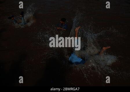 Lahore, Pakistan. Mai 2020. Pakistanische Jugendliche genießen Bad im Kanalwasser, um die Hitze zu schlagen und etwas Erleichterung von warmem Wetter in Ramazan-ul-Mubarak in Lahore. (Foto von Rana Sajid Hussain/Pacific Press) Quelle: Pacific Press Agency/Alamy Live News Stockfoto