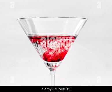 Einzelne helle rote Farbtropfen getrennt vom Wasser in kristallklaren martini-Gläser, Virginia, USA, Nordamerika, Farbe Stockfoto