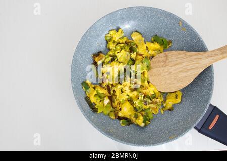 Direkt über dem Schuss aus Lauch und Eiern in einer Pfanne auf weißem Hintergrund Stockfoto