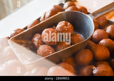 Viele kleine runde, frittierte Donuts, einfach, ohne Sirup oder Dippsauce. Große Schüssel Donuts isoliert, bereit, während des Food Festival oder c serviert werden Stockfoto