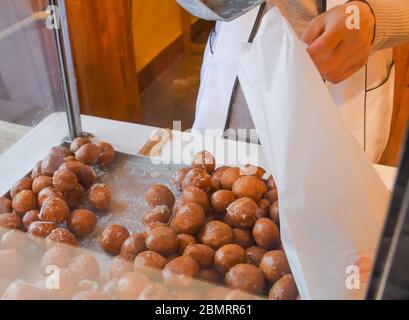 Viele kleine runde, frittierte Donuts, einfach, ohne Sirup oder Dippsauce. Große Schüssel Donuts isoliert, bereit, während des Food Festival oder c serviert werden Stockfoto