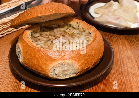 Die saure Suppe (zurek) von Roggenmehl mit Wurst und Ei in Brot