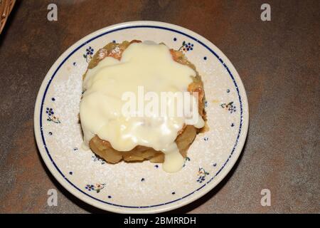 Traditionelle warme polierte Apfelkuchen mit Vanillecreme auf der Oberseite in einem berühmten Restaurant namens Gościniec - Polskie Pierogi in Warschau, Polen serviert Stockfoto