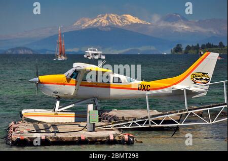 Cessna schweben an seinem Liegeplatz am Lake Taupo, auf der Nordinsel Neuseelands. Im Hintergrund sind die Zapfen des Vulkangelateaus. Stockfoto