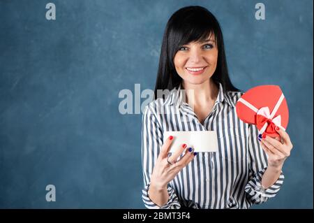 Schönes Mädchen, Brünette öffnet die Box als Herz, ein Geschenk. Valentinstag, Hand und Herz Vorschlag, Ehe, Liebe, Raum für Text Stockfoto