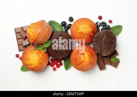 Muffins, Beeren und Schokolade auf weißem Hintergrund, Draufsicht Stockfoto