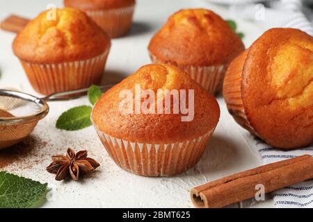 Komposition mit Muffins und Zimt auf weißem Hintergrund Stockfoto