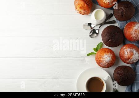 Zusammensetzung mit Muffins und Kakao-Getränk auf weißem Holzhintergrund Stockfoto
