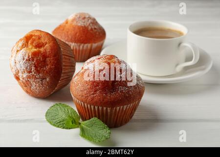 Leckere Muffins und Kakao-Getränk auf weißem Holzhintergrund Stockfoto