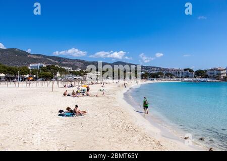 Palmanova, Mallorca, Spanien - 13. April 2019: Touristen, die ein Sonnenbad am Strand Platja de Palmanova, Mittelmeer, Balearen. Stockfoto