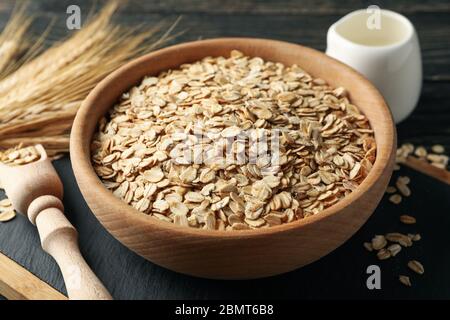 Zusammensetzung mit Haferflocken und Milch auf Holzhintergrund Stockfoto