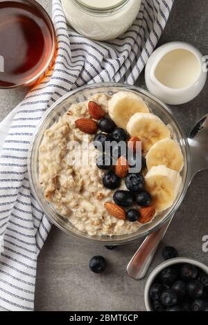 Zusammensetzung mit Haferbrei Haferbrei mit Früchten auf grauem Hintergrund Stockfoto