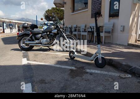 Port d'Andratx, Mallorca, Spanien - 13. April 2019: Parken von E-Scootern auf einem Motorradparkplatz in Port d Andratx Stockfoto