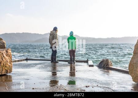 Zwei Kinder auf einem Dock an einem stürmischen Tag. Stockfoto