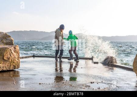 Zwei Kinder auf einem Dock an einem stürmischen Tag. Stockfoto