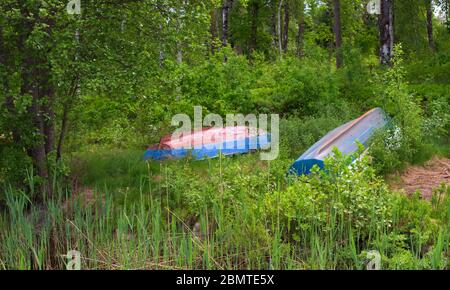 Kleine Plastikboote liegen kopfüber im Gras. Stockfoto