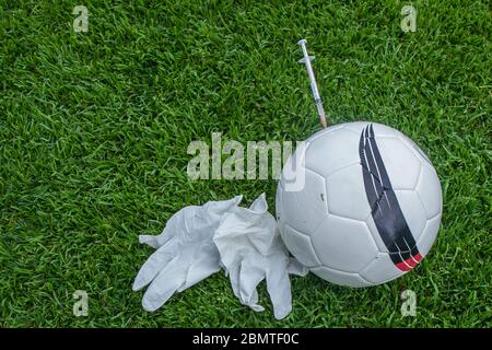 Bamberg, Deutschland. Mai 2020. Bamberg, 10. Mai 2020: Symbolbilder - Coronavirus - 10.05.2020 EINE Spritze mit Covid-19 Schriftzug ist im Fußball auf dem Platz, daneben Gummihandschuhe, Feature/Symbol/Symbol Foto/Merkmal/Detail/ Verwendung weltweit Credit: dpa/Alamy Live News Stockfoto