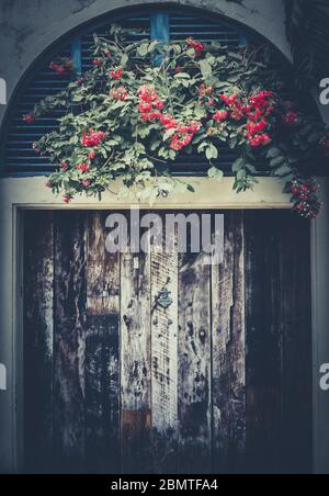 Alte verfallende Holztür und Blumen Vorderansicht Stockfoto