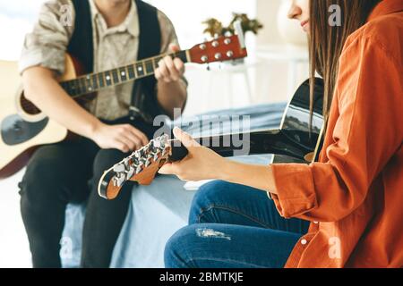 Lernen, Gitarre zu spielen. Der Lehrer erklärt dem Schüler die Grundlagen des Gitarrenspiels. Individuelle Hausschulausbildung oder außerschulischer Unterricht. Stockfoto