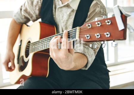 Der Gitarrist spielt Gitarre. Oder eine Person lernt, Gitarre zu spielen. Stockfoto