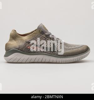 WIEN, ÖSTERREICH - 19. FEBRUAR 2018: Nike Free RN Flyknit 2018 Khaki und grauer Sneaker auf weißem Hintergrund. Stockfoto