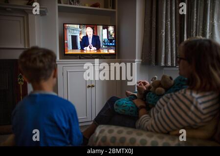 Familie beobachtet Premierminister Boris Johnson, der im nationalen Fernsehen die britische Nation anRede und die Schritte eines "Road Map" aus der Sperrung des Coronavirus aufführt Stockfoto