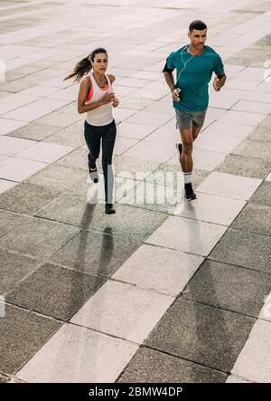 Paar in Sportbekleidung Training zusammen in der Stadt. Sportliche Männer und Frauen laufen zusammen in der Stadt. Stockfoto