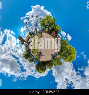 Grüner kleiner Planet mit Bäumen, weißen Cluds und weichem blauen Himmel. Kleiner Planet des Vergnügungsparks. 360 Betrachtungswinkel. Stockfoto