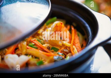 Vietnamesisches Meeresessen im Topf.köstliche gekochte Garnelen und Gemüse in asiatischem Restaurant.exotische Jambalaya-Gericht mit Garnelen und weißem Hühnerfleisch Stockfoto