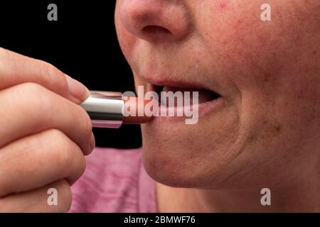 Frau über 50 mit Lippenstift Stockfoto