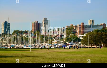 9. Mai 2018 - Sydney, Australien: Blick auf Segelboote in der Rushcutter's Bay mit Rugby-Platz im Vordergrund und Wolkenkratzern im Hintergrund Stockfoto