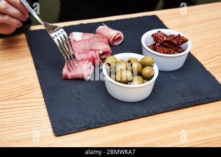 Kalt geräucherter Fleischplatte mit Schinken, Salami, Speck, Käse und Oliven auf Holzhintergrund. Draufsicht Stockfoto