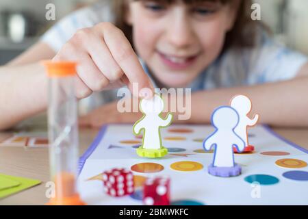 Lächelndes Mädchen Spielen Generische Brettspiel Zu Hause Stockfoto